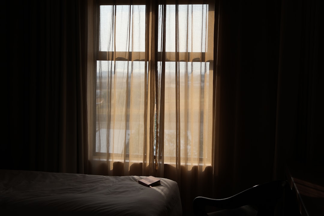 Chambre d'hôtel au petit matin avec un rai de lumière entre les rideaux
