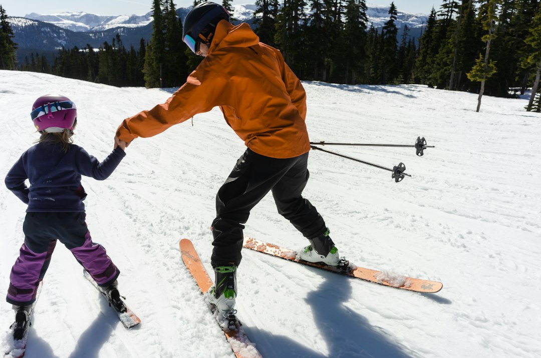 Monitrice apprenant à skier à un jeune enfant sur une piste douce