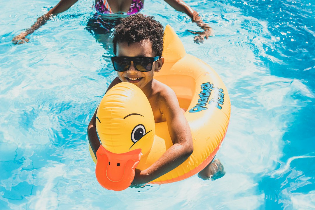 Enfant dans une piscine avec une bouée canard en vacances