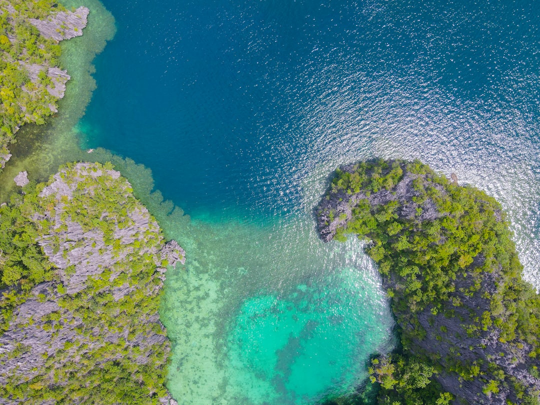 Baie tropicale bordée de pitons calcaires vue depuis le ciel